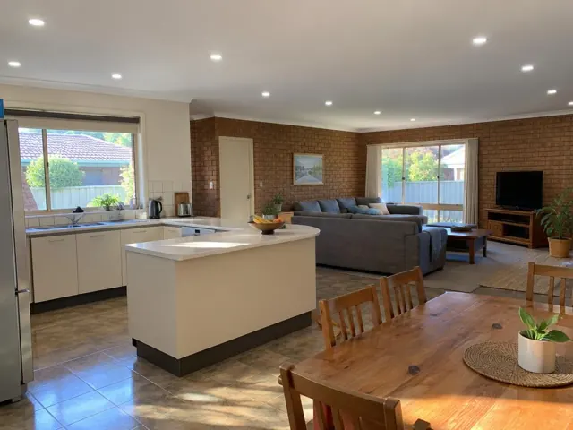 Living room and kitchen with recessed ceiling downlights in a brick home interior in Berkeley Vale